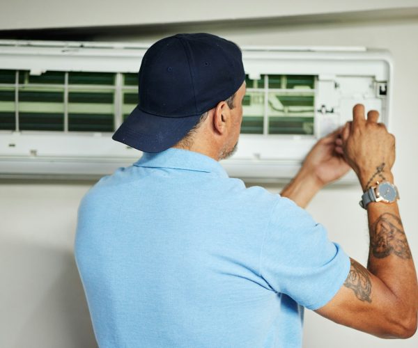 Man, electrician and ac repair for air conditioner maintenance from the back. Mechanic, technician